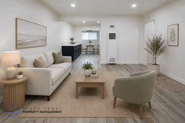 Newport Beach townhouse for rent - A living room with a white couch, a wooden coffee table, and a lamp on a side table.