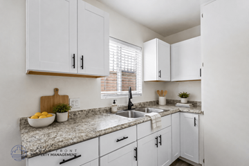 Hawthorne apartment for rent - A kitchen with white cabinets and a granite countertop.