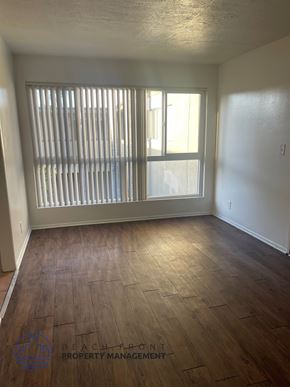 Lynwood apartment for rent - A room with wooden floors and a window with blinds.