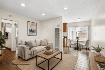 Downey apartment for rent - A living room with a couch, a coffee table, and a dining table with chairs.
