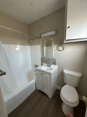Anaheim apartment for rent - A white toilet sits next to a white sink in a small bathroom.