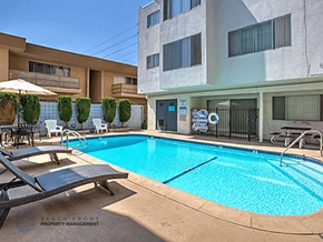 Inglewood apartment for rent - A pool surrounded by a patio with chairs and a building in the background.