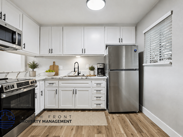 Lomita apartment for rent - A modern kitchen with white cabinets and stainless steel appliances.