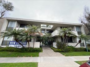 Torrance apartment for rent - the front of a white house with palm trees in front of it