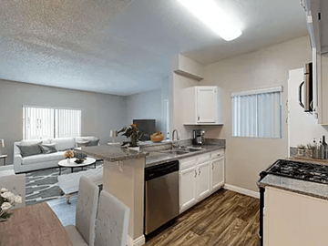 Anaheim apartment for rent - A kitchen with a stove top oven and a dining table.
