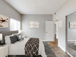 Anaheim apartment for rent - A bedroom with a bed, nightstand, and two framed pictures on the wall.