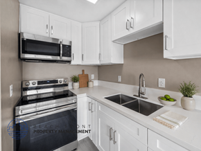 Whittier apartment for rent - A modern kitchen with white cabinets and a black stove top oven.