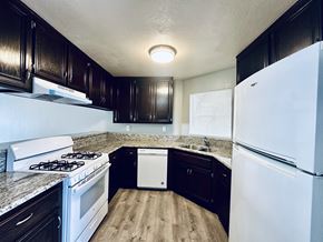 Long Beach apartment for rent - A kitchen with a white fridge and a white dishwasher.
