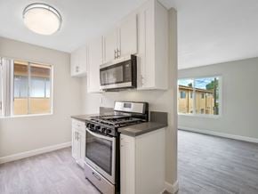 Downey apartment for rent - A kitchen with a stove, microwave, and oven.