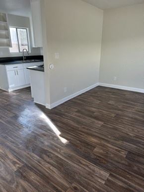 Downey apartment for rent - an empty kitchen and living room with wood flooring