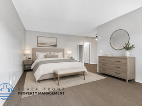 Lomita apartment for rent - A well-lit bedroom with a large bed, a side table with a lamp, and a dresser with a mirror.
