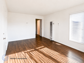 Lynwood apartment for rent - A room with wooden floors and white walls, with a door and a window.