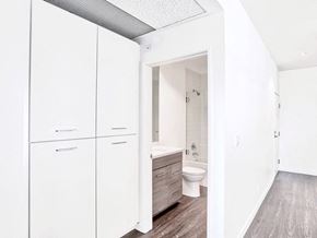 Hollywood apartment for rent - a white bathroom with white cabinets and a toilet