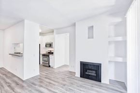 Los Angeles apartment for rent - an empty living room with a fireplace and a kitchen