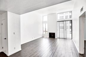 Hollywood apartment for rent - an empty living room with hard wood floors and a fireplace