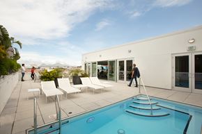 New Orleans apartment for rent - A man is walking towards a pool on a sunny day.
