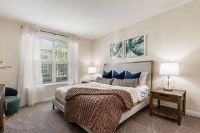 Grove City townhouse for rent - A bedroom with a large bed and a window with curtains.