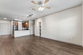 New Braunfels apartment for rent - A spacious room with a ceiling fan and wooden flooring.
