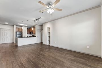 New Braunfels apartment for rent - A spacious room with a ceiling fan and wooden flooring.