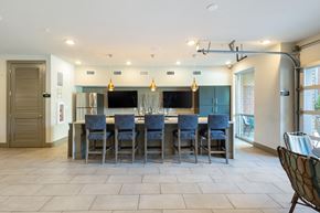 Atlanta apartment for rent - a large kitchen with a large island with blue chairs and a bar with chairs