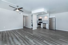 Phoenix apartment for rent - an empty living room with a kitchen and a ceiling fan