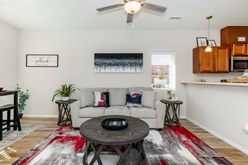 Albuquerque apartment for rent - A living room with a white couch and a red rug.