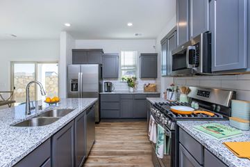 El Paso apartment for rent - A modern kitchen with dark grey cabinets and stainless steel appliances.