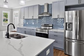 Spring Hill apartment for rent - A modern kitchen with a stainless steel refrigerator and a marble countertop.