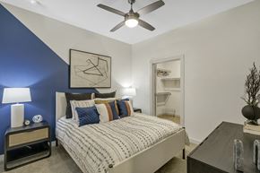 Dallas apartment for rent - A bedroom with a bed, nightstand, and a ceiling fan.