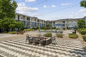 Lone Tree apartment for rent - A patio with a table and chairs is in front of a building.