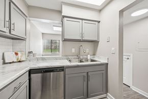Hillsborough townhouse for rent - A kitchen with a stainless steel dishwasher and a white countertop.
