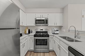 Grayslake apartment for rent - a kitchen with stainless steel appliances and white cabinets
