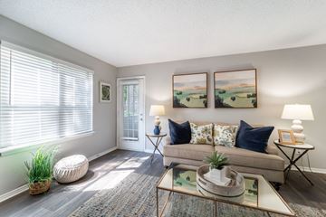 Smyrna apartment for rent - A living room with a couch, a table, and two paintings on the wall.