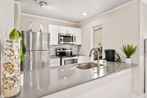 Dallas apartment for rent - a kitchen with white cabinets and stainless steel appliances
