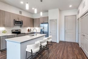 Anna apartment for rent - A kitchen with a white counter and white chairs.