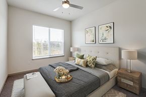 Anna apartment for rent - A bedroom with a large bed, a ceiling fan, and two framed pictures on the wall.