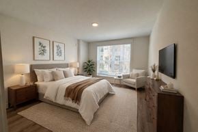 Charlotte apartment for rent - A bedroom with a large bed and a flat screen TV mounted on the wall.