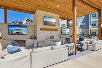 Denton apartment for rent - A person is lying on a couch in a living room with a television and a fireplace.