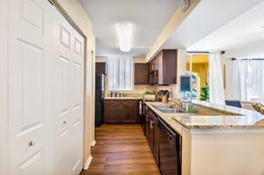 Sunrise apartment for rent - A kitchen with brown cabinets and a white door.