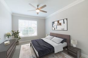 Houston apartment for rent - a bedroom with a bed and a ceiling fan