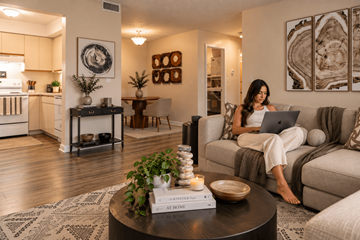 Port Saint Lucie apartment for rent - A woman is sitting on a couch with a laptop in a well-lit living room.