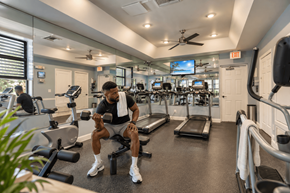 Port Saint Lucie apartment for rent - A man is working out in a gym with a variety of equipment.
