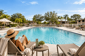 Port Saint Lucie apartment for rent - A woman in a straw hat is reading a book by the pool.