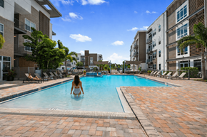 Tarpon Springs apartment for rent - A woman is sitting in a pool surrounded by buildings.