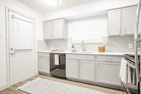 Arlington apartment for rent - a white kitchen with white cabinets and a stainless steel refrigerator