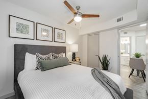 Dallas apartment for rent - A bedroom with a large bed and a ceiling fan.