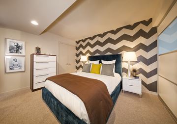Washington apartment for rent - A bedroom with a large bed and a chevron patterned wall.