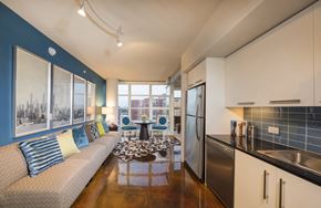 Washington apartment for rent - A kitchen with a refrigerator, sink, and a couch with pillows.