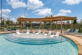 Fort Worth apartment for rent - A pool with a wooden pergola and lounge chairs.
