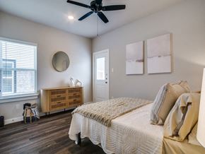 Fort Worth apartment for rent - A bedroom with a bed, a ceiling fan, and a window with blinds.